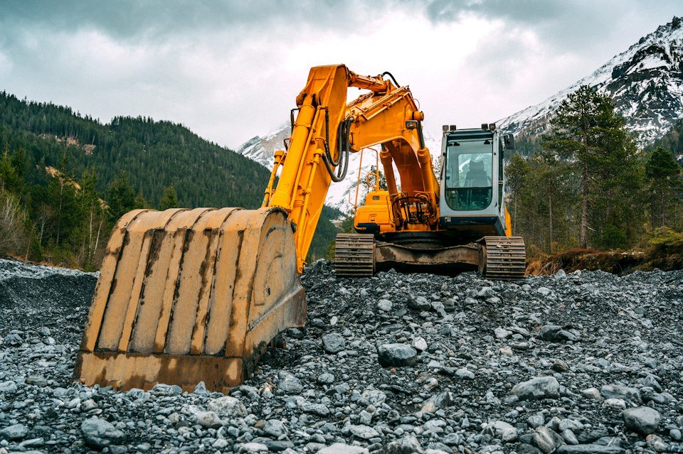 Excavator on rocky ground, representative of heavy equipment consignments