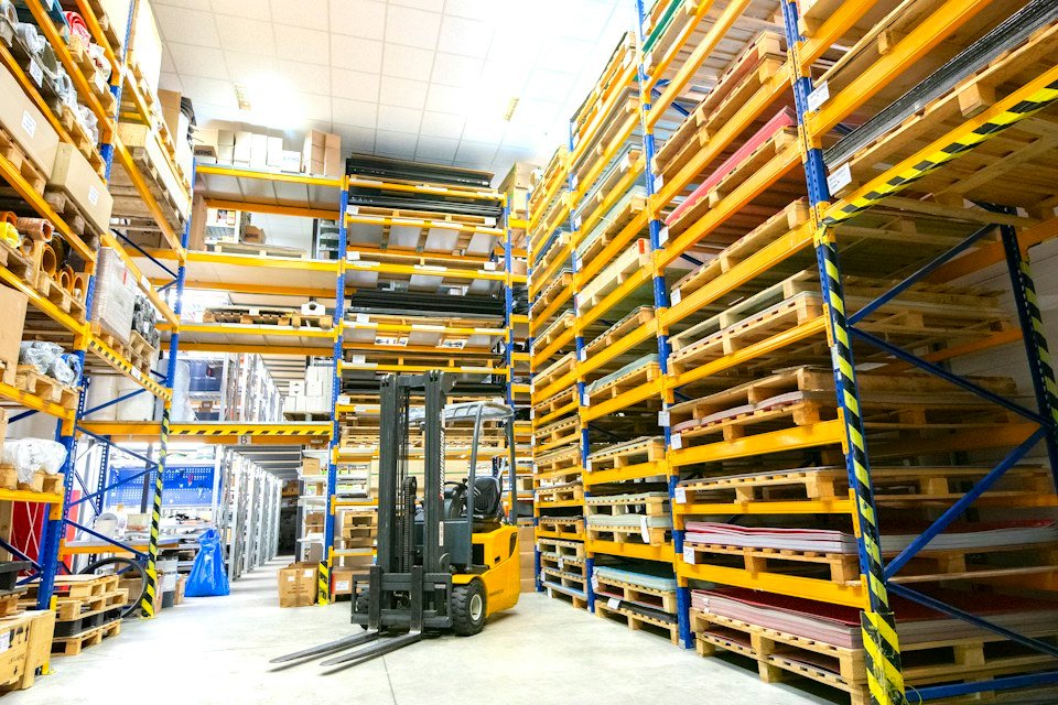 Warehouse shelving with stacked pallets, representative of business liquidation and surplus consignments