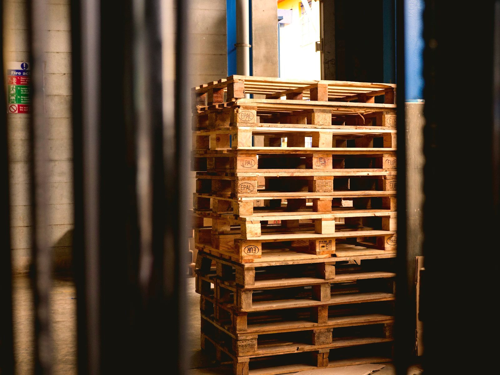 Wooden pallets stacked in a storage building, representative of consignment intake and staging